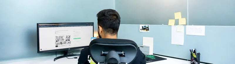 An engineer at a desk with an ultrawide monitor